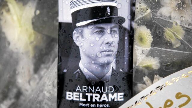Una foto del teniente coronel Arnaud Beltrame junto a un ramo de flores en la comisaría de Carcasona