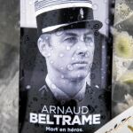 Una foto del teniente coronel Arnaud Beltrame junto a un ramo de flores en la comisaría de Carcasona