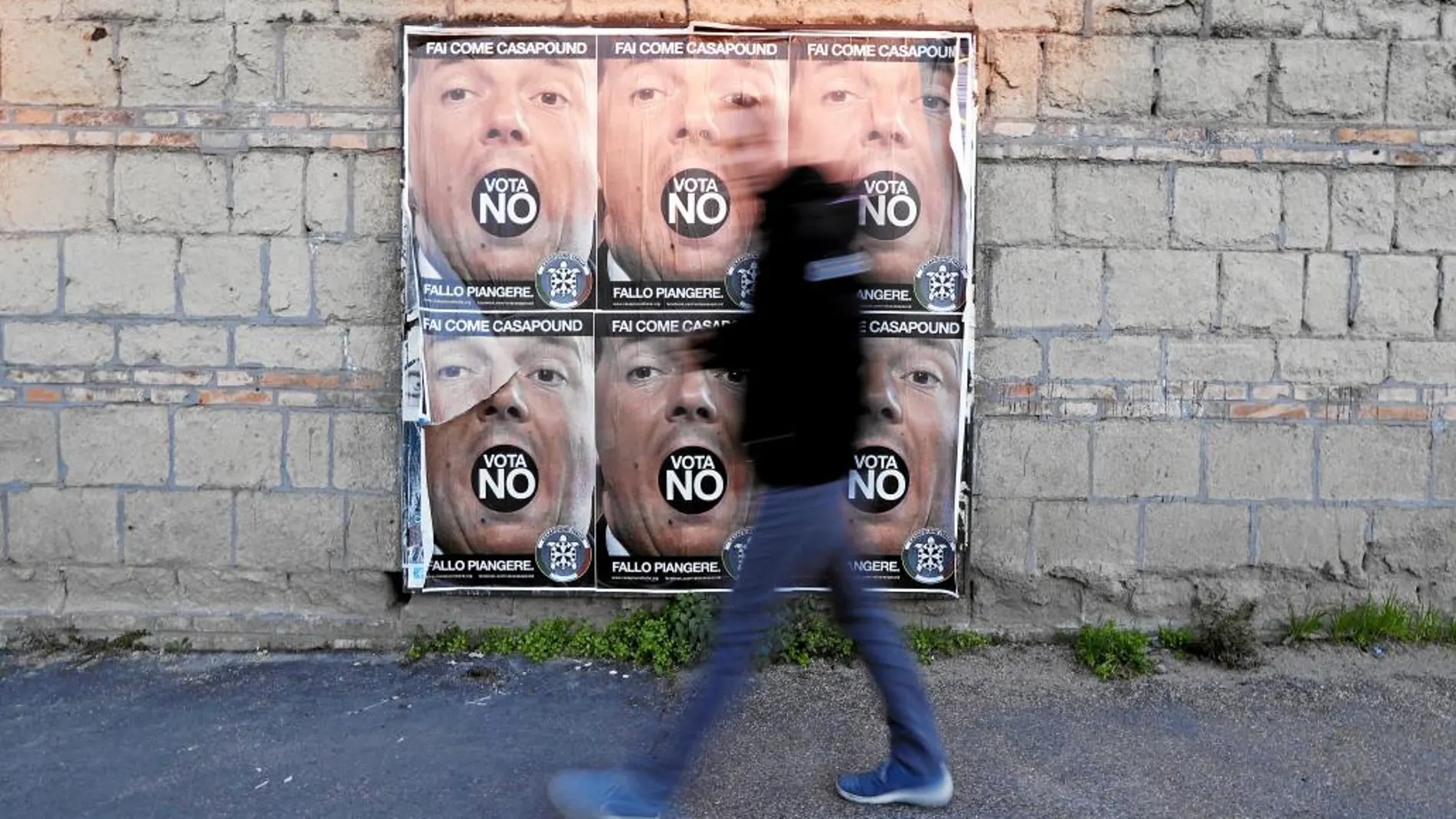 Un transeúnte pasa en Roma junto a un cartel a favor del «no» en el referéndum constitucional de este domingo