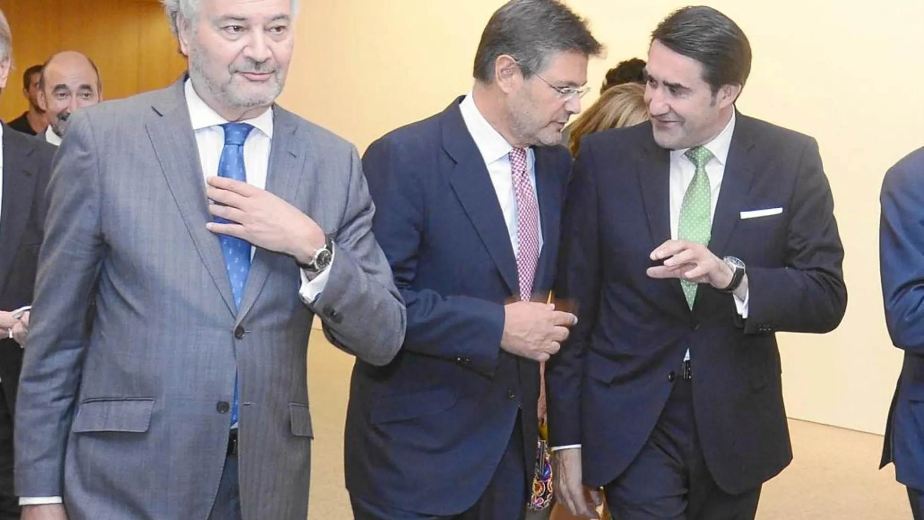 El consejero Suárez-Quiñones conversa con el ministro Catalá, en presencia de Juan Carlos Estévez
