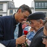 Pedro Sánchez recibe una rosa de un antiguo militante socialista, al final del mitin que celebró el PSdG-PSOE en la localidad lucense de Vilalba