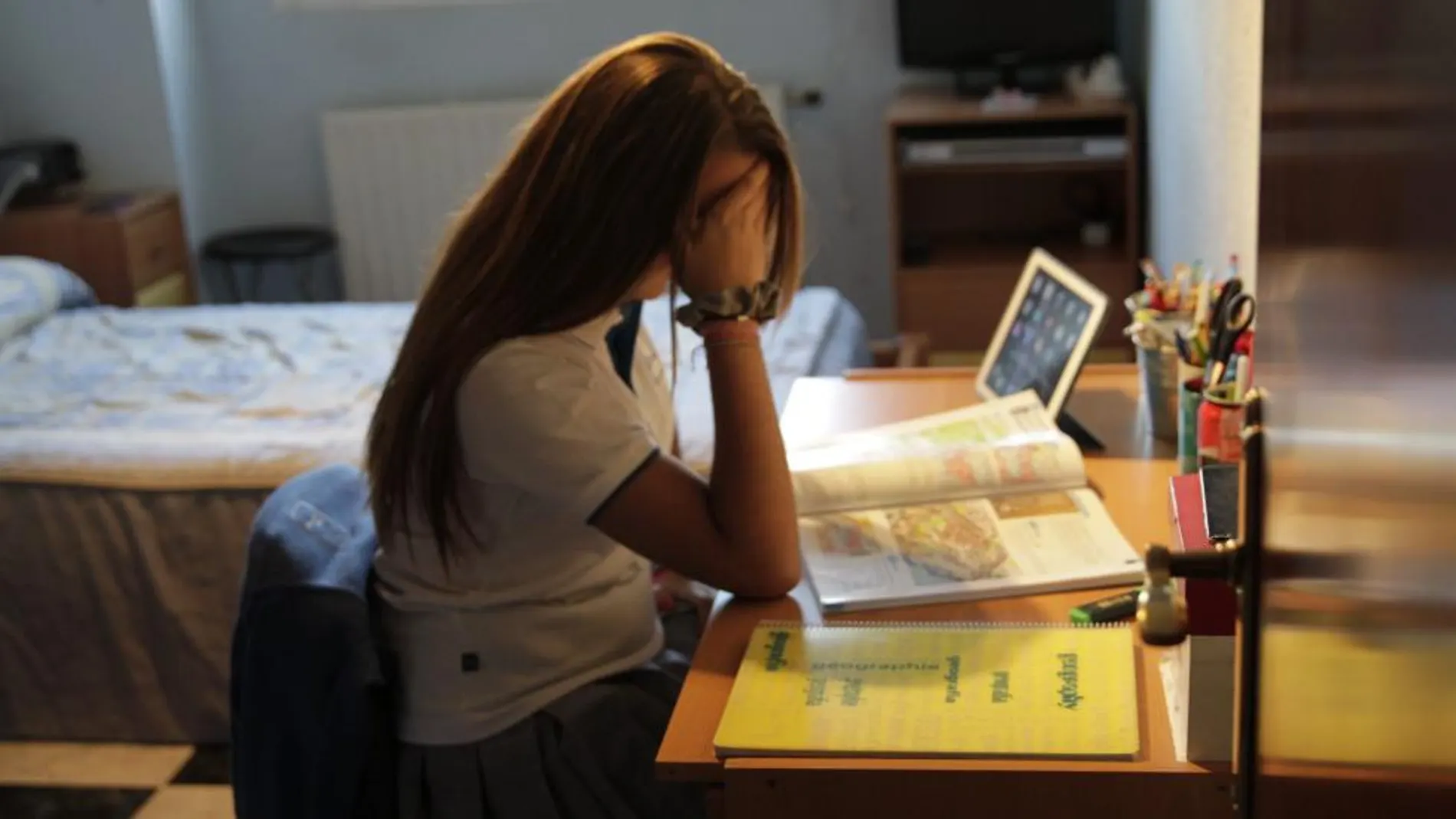 Una joven víctima de acoso escolar estudia en su casa tras haber tenido que cambiar de centro académico al sufrir una agresión
