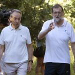 El presidente del Gobierno, Mariano Rajoy (d), acompañado por el presidente de la Autoridad Portuaria de Marín, José Benito Suárez (i), durante su paseo por las orillas del río Umia.
