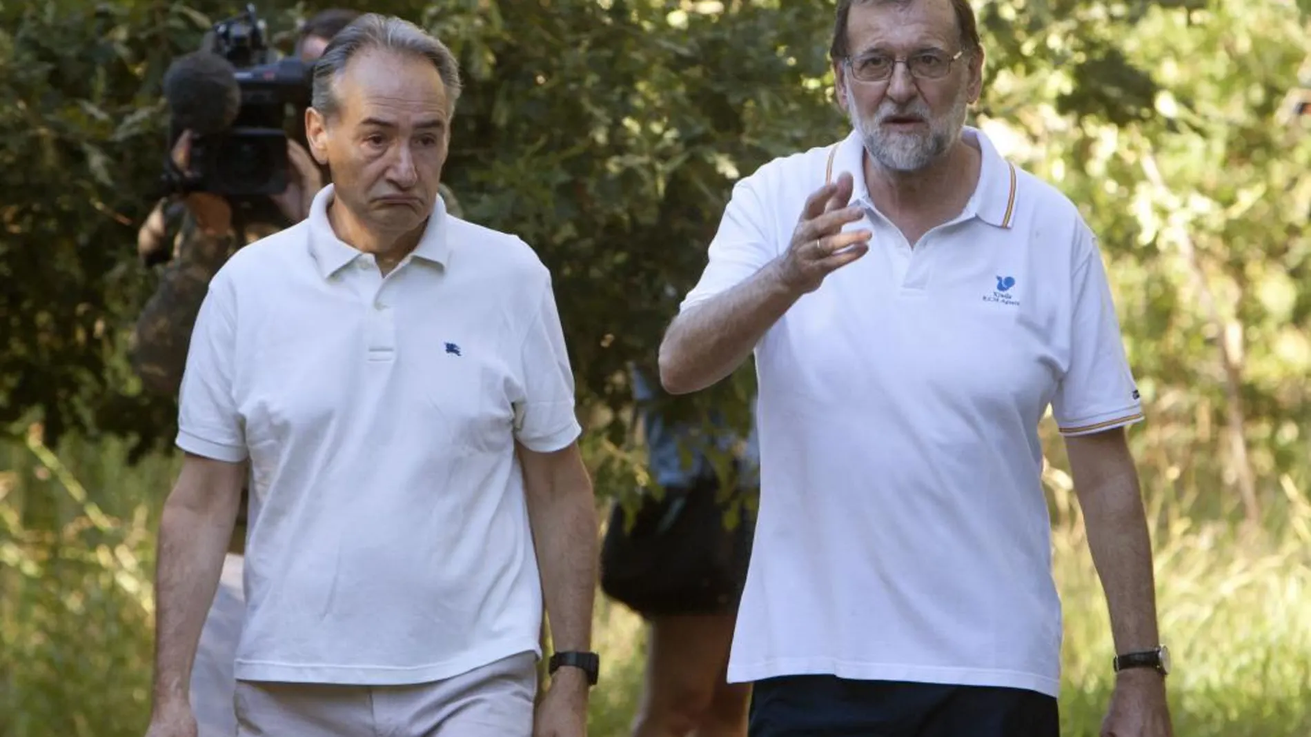 El presidente del Gobierno, Mariano Rajoy (d), acompañado por el presidente de la Autoridad Portuaria de Marín, José Benito Suárez (i), durante su paseo por las orillas del río Umia.