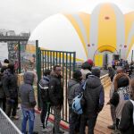 Migrantes acceden al centro de acogida que abrió sus puertas ayer en París y que puede acoger a 400 personas