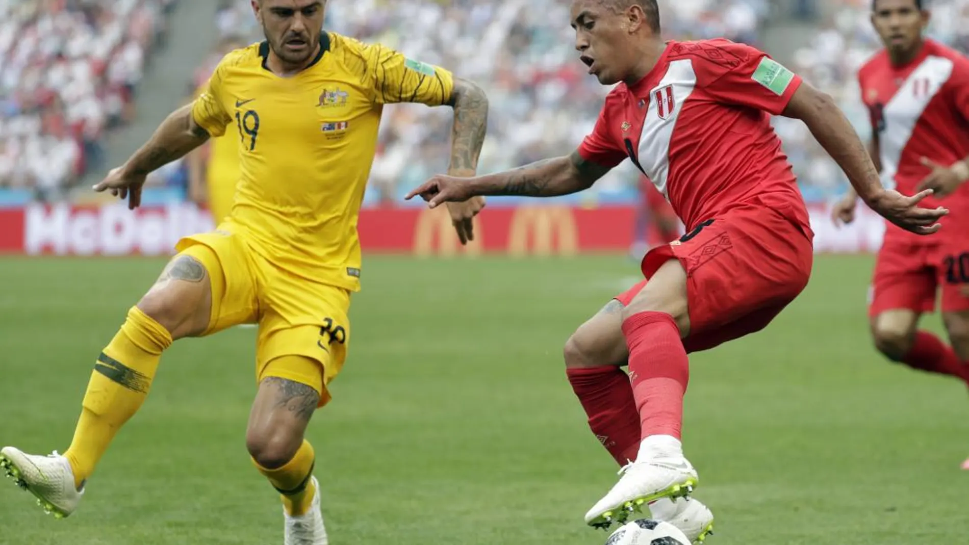 El australiano Joshua Risdon lucha por robarle el balón al mediocentro peruano Christian Cueva / Ap