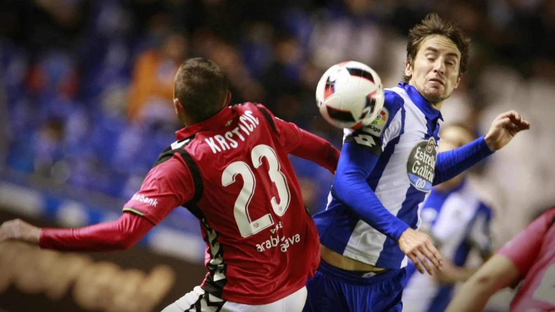El centrocampista del Deportivo de La Coruña Pedro Mosquera (d) pelea un balón con el serbio Nenad Krsticic, del Deportivo Alavés, durante el partido