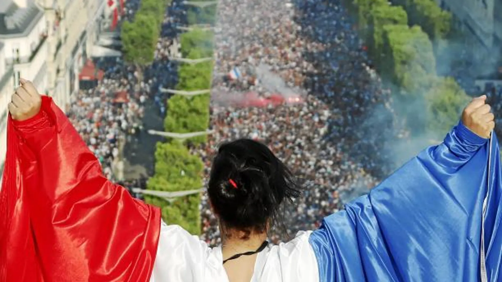 Una aficionada con la bandera de Francia celebra el triunfo en los Campos Elíseos / Reuters