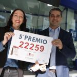 El dueño de la administración de lotería número 3 de Aguadulce, junto a la empleada Belén Ortíz, sostienen el cartel con el número 22.259 premiado con un quinto premio