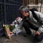 Un hombre deposita flores en la capilla de Gonville and Caius College en Cambridge (Reino Unido) como tributo al fallecido científico Stephen Hawking