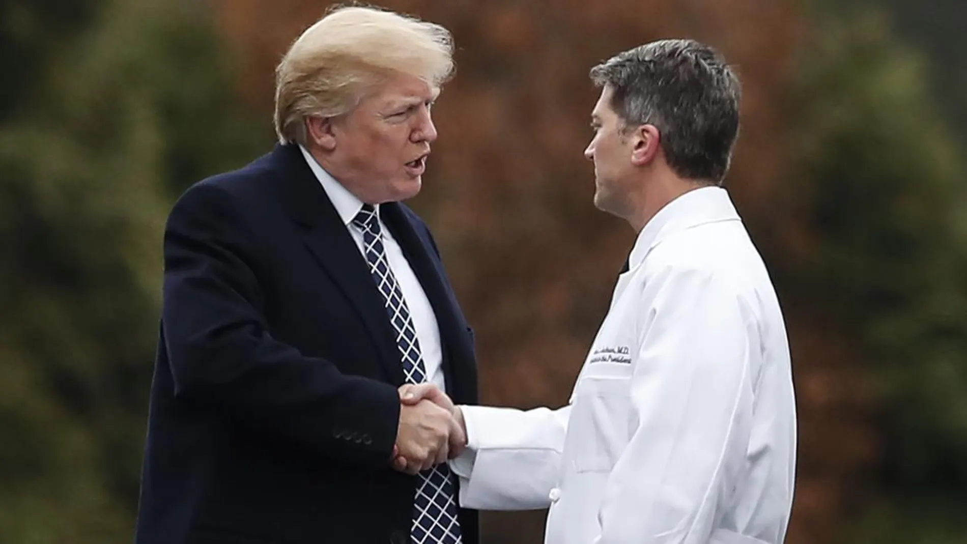 Donald Trump estrecha la mano al doctor Ronny Jackson.