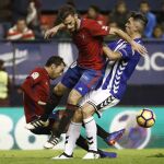 Los centrocampistas Miguel de las Cuevas y Roberto Torres, del Osasuna, intentan arrebatar el esférico al centrocampista del Deportivo Alavés, Víctor Camarasa
