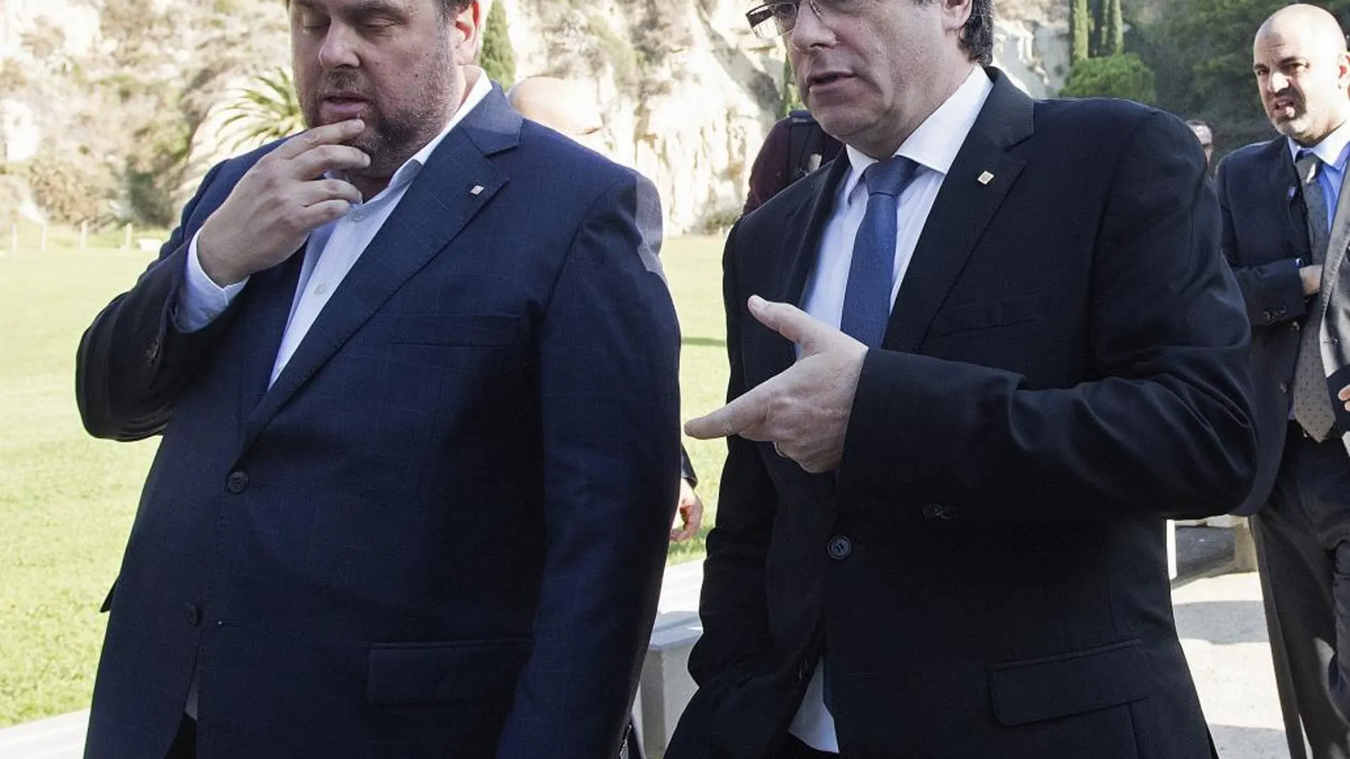 El presidente de la Generalitat, Carles Puigdemont (d), conversa con el vicepresidente Oriol Junqueras (i), tras asistir a la tradicional ofrenda ante la tumba del presidente de la Generalitat republicana Lluís Companys