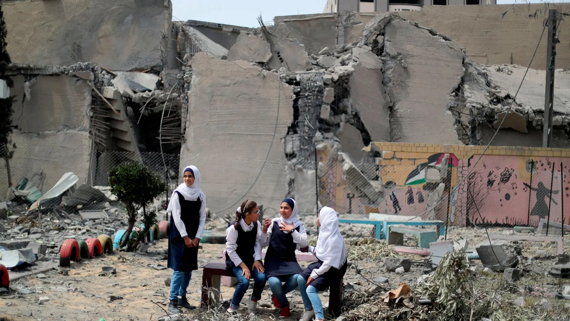 Estudiantes palestinas cerca de su escuela, destruida durante los bombardeos de Israel, en Ciudad de Gaza/ Reuters