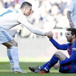 Cristiano ayuda a Messi a levantarse durante un Clásico