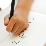 Un niño zurdo escribe en un cuaderno