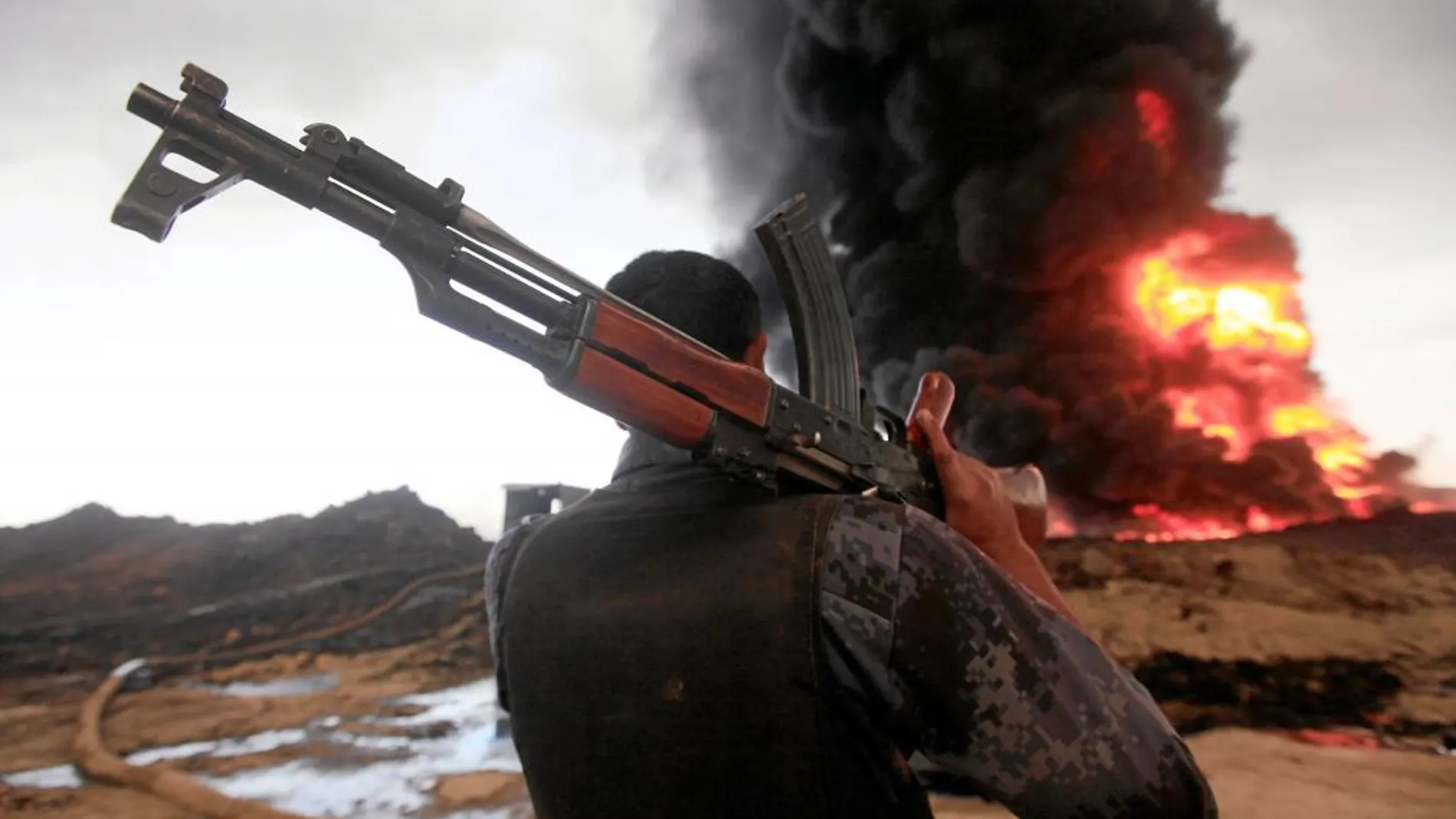 ENTRE LLAMAS. Un soldado contempla en Irak cómo arde un pozo de petróleo. El Estado Islámico provocó el incendio este año