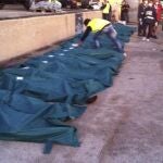 Una fila de cadáveres recuperados de un barco procedente de Libia yacen en un muelle del puerto de Lampedusa en agosto de 2011