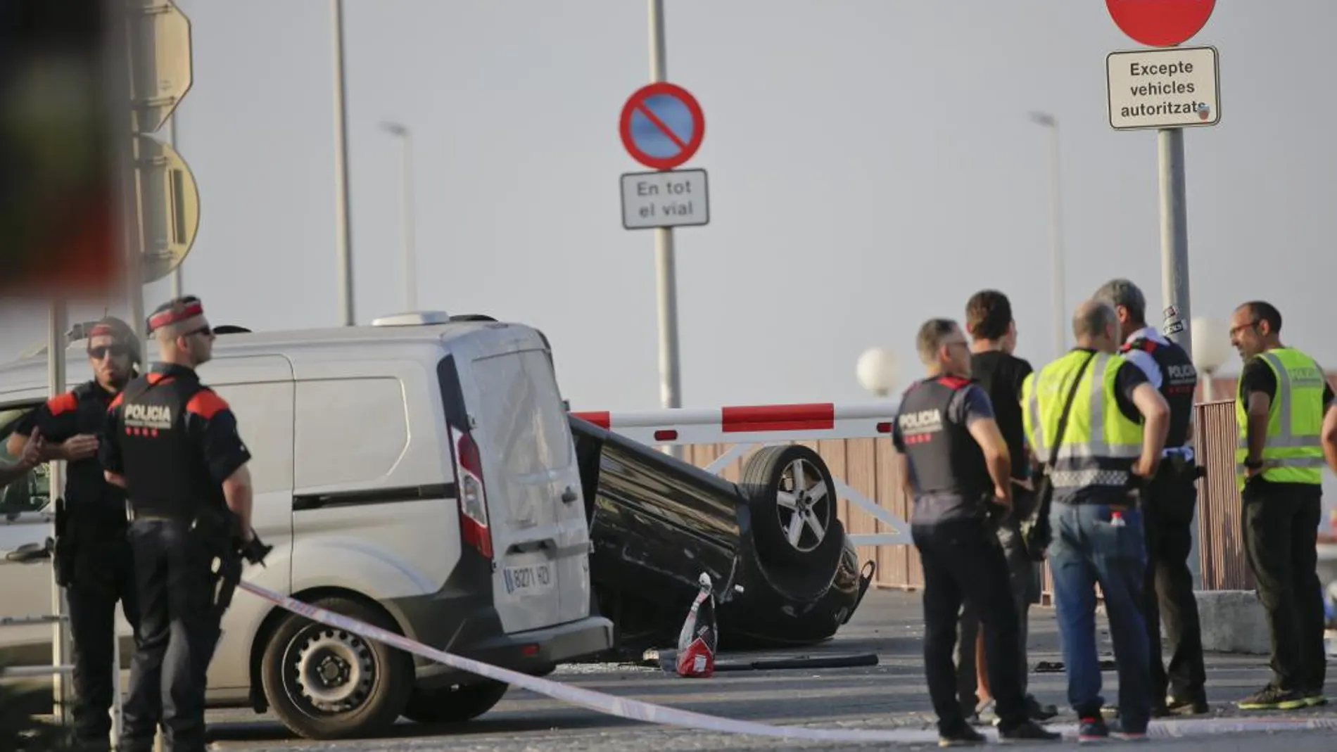 Los agentes, junto al coche en el que fueron interceptados los terroristas abatidos en Cambrils.