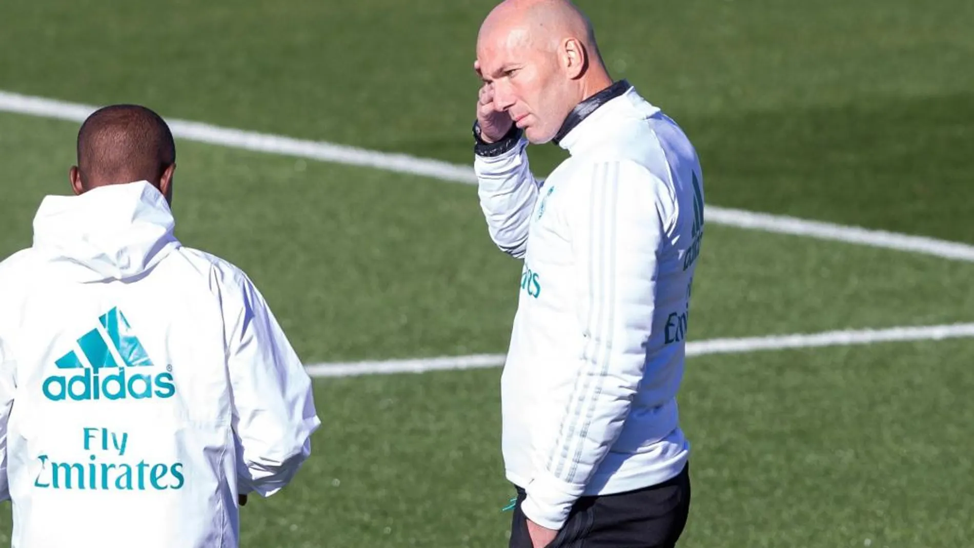 El entrenador del Real Madrid Zinedine Zidane (d) conversa con su ayudante Hamidou Msaidie (i) durante el entrenamiento realizado hoy.