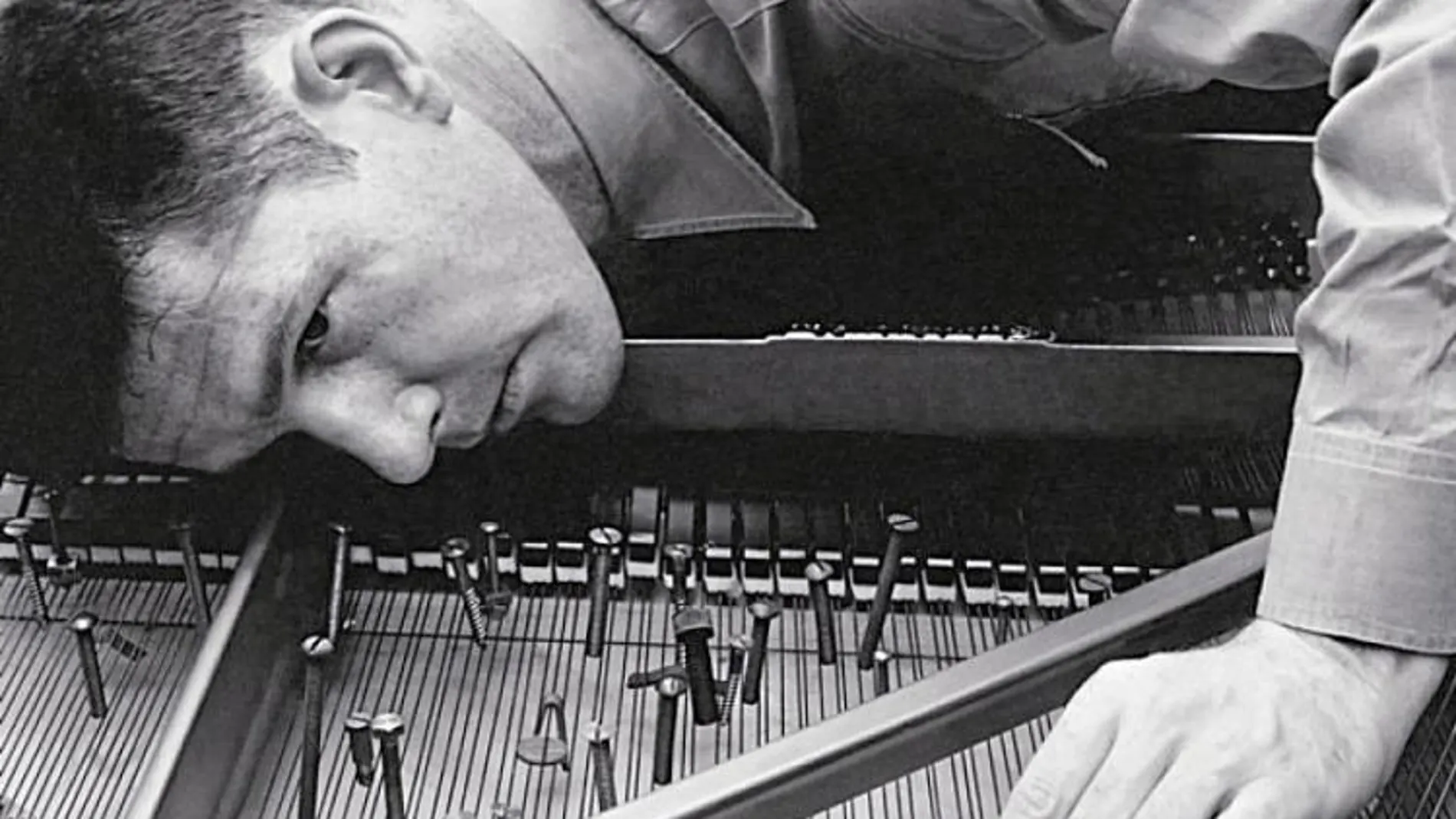 El compositor fuma un cigarrillo entre las cuerdas de un piano