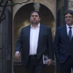 El vicepresidente del gobierno catalán y conseller de Economía y Hacienda, Oriol Junqueras (i), y el presidente de la Generalitat, Carles Puigdemont (d), se dirigen a la reunión del Govern
