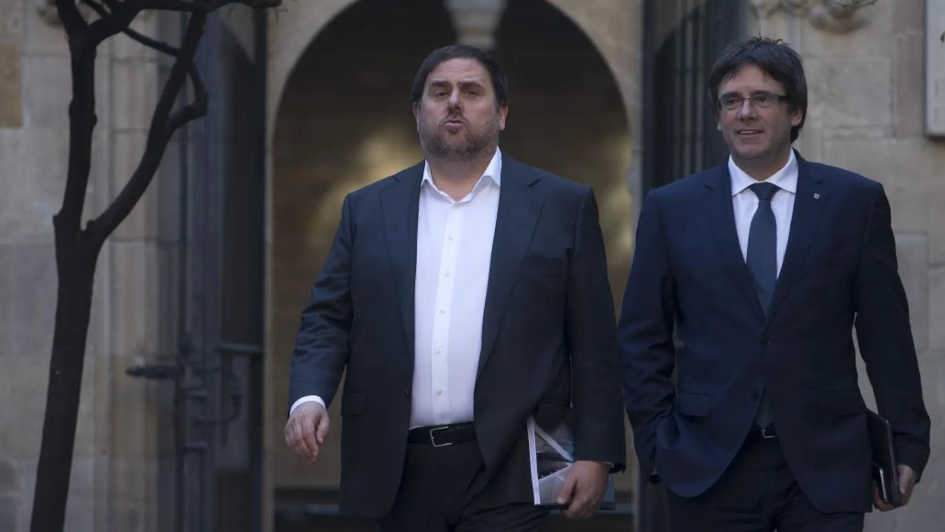 El vicepresidente del gobierno catalán y conseller de Economía y Hacienda, Oriol Junqueras (i), y el presidente de la Generalitat, Carles Puigdemont (d), se dirigen a la reunión del Govern