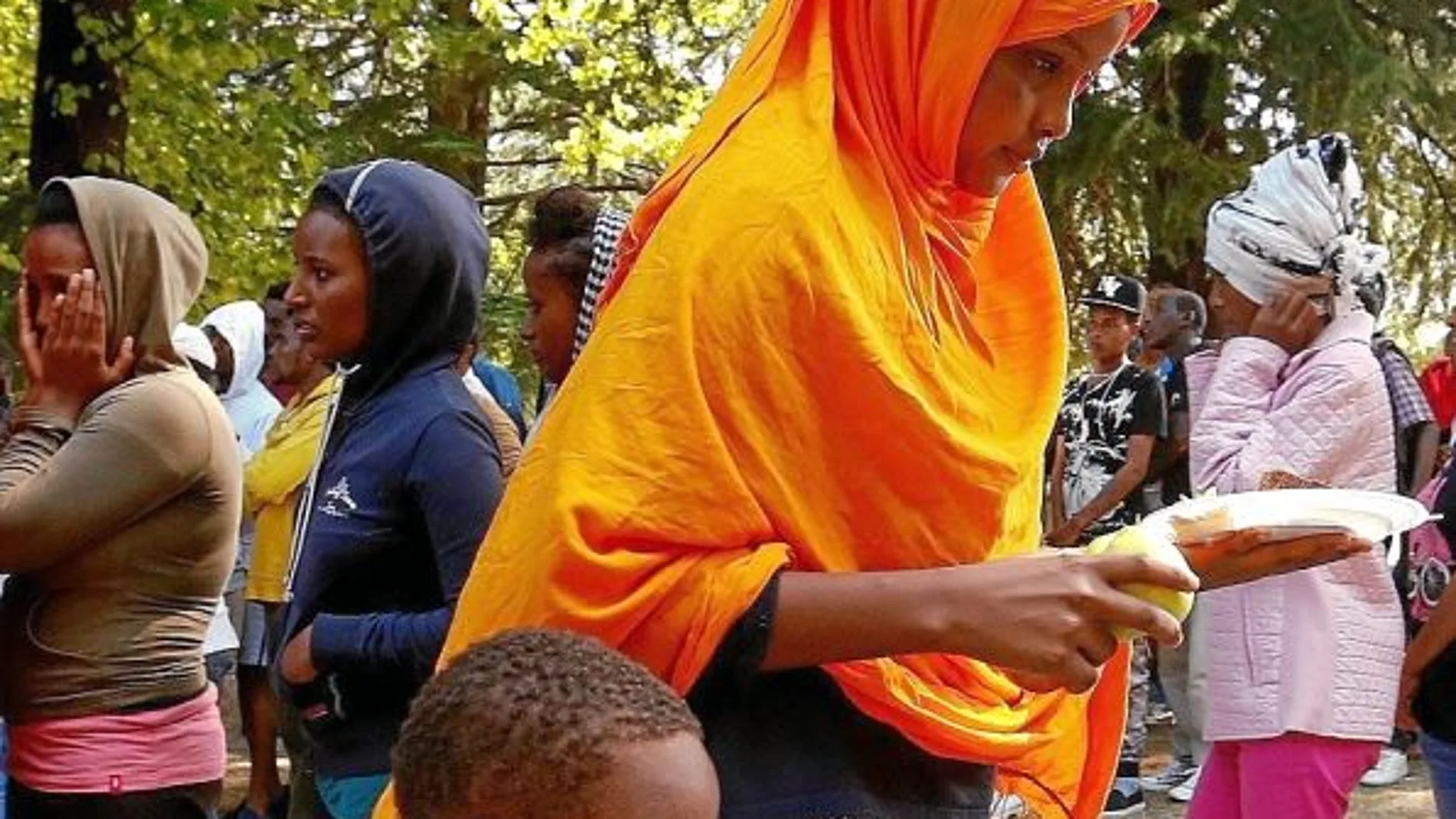 Voluntarios reparten comida entre los refugiados en un parque de Como