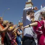 Unos jóvenes bailan junto a la portada de la Feria de Abril de Sevilla en ediciones anteriores