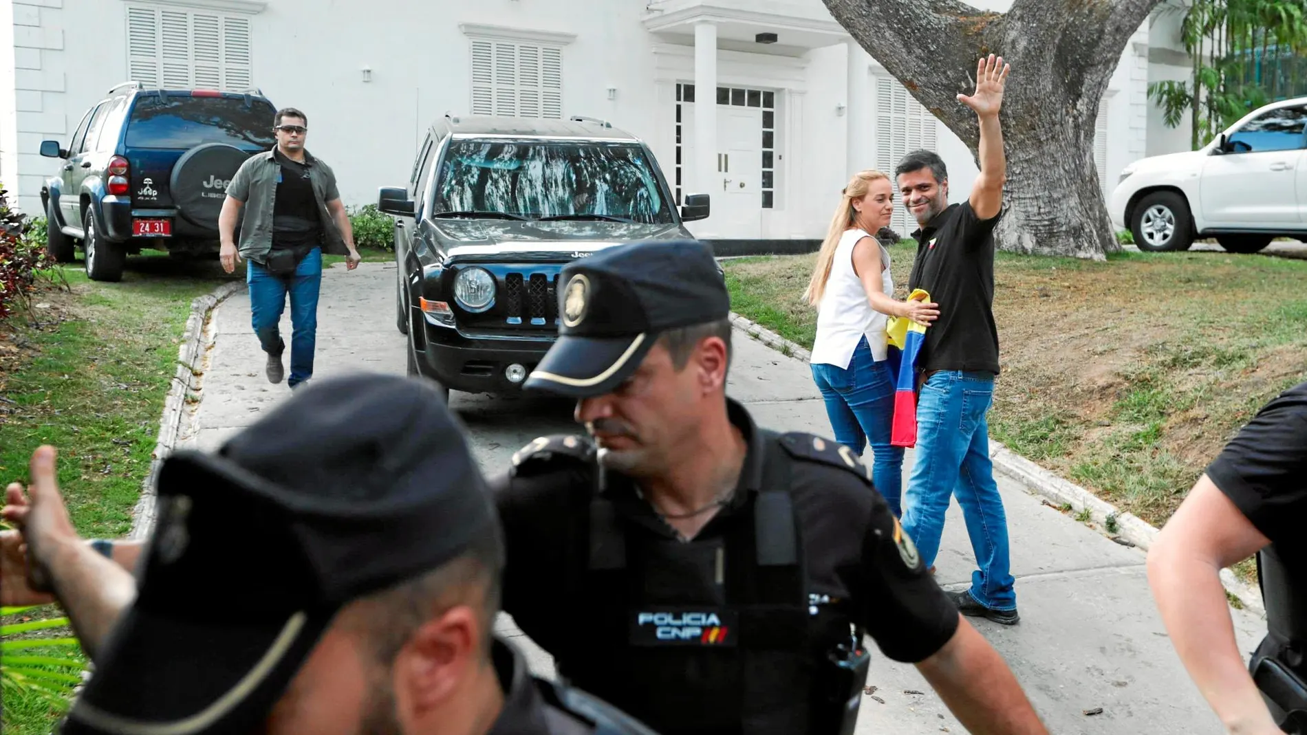 Leopoldo López y su esposa, Lilian Tintori, custodiados por la Policía Nacional, tras su declaración ayer a la entrada de la residencia del embajador español en Caracas / Efe