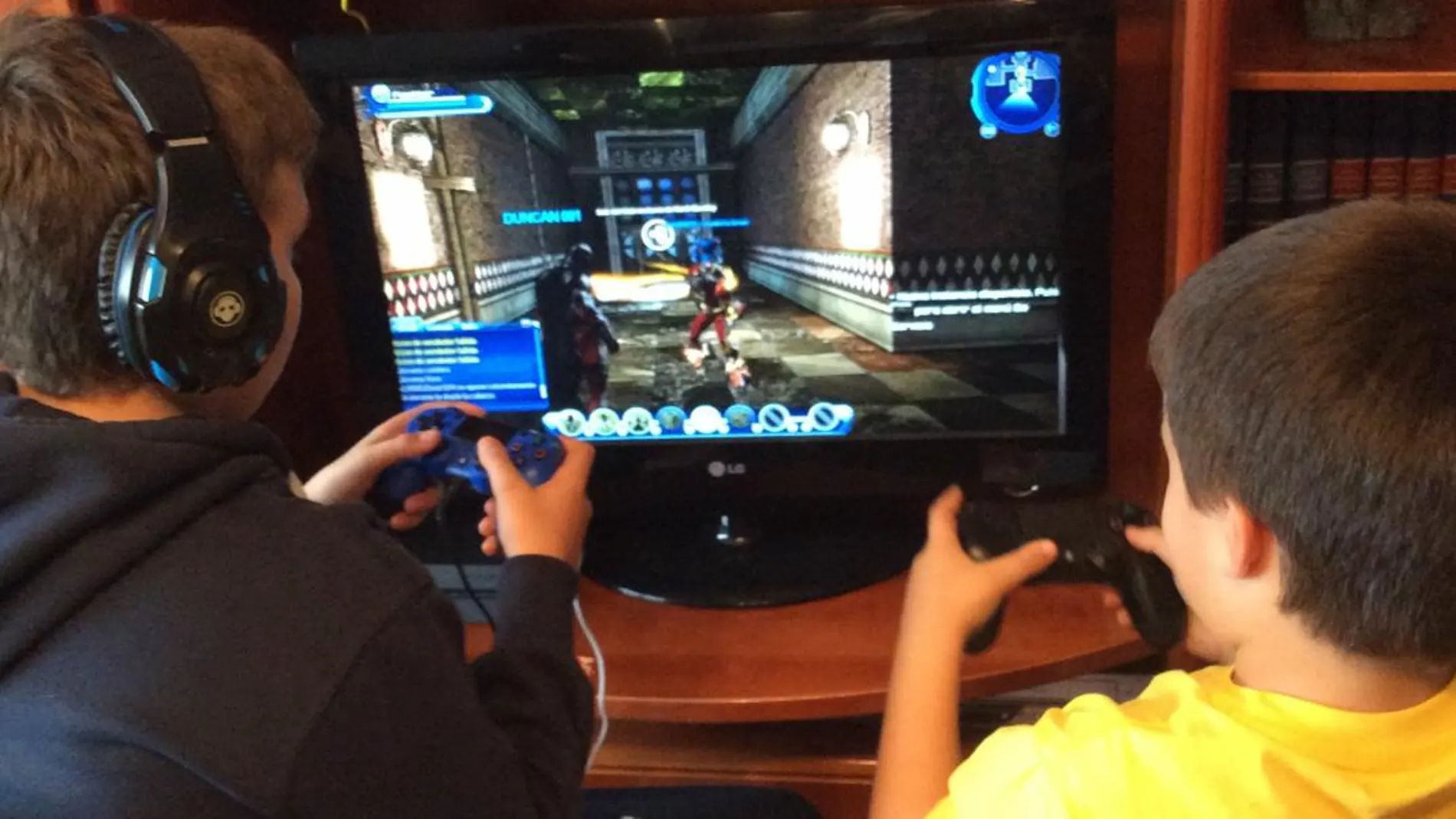 Dos niños jugando a un videojuego en casa