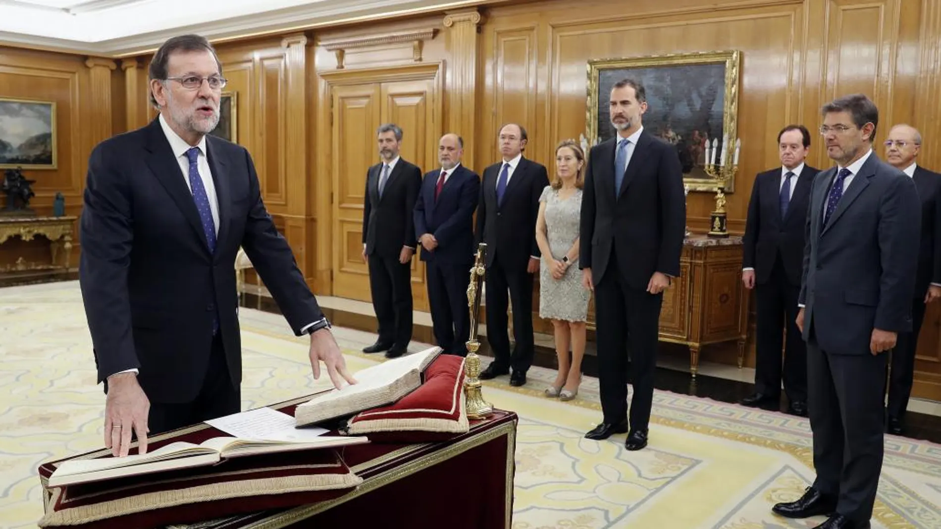 El reelegido presidente del Gobierno, Mariano Rajoy (i), jura el cargo ante el Rey.