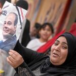 Una mujer muestra una fotografía del presidente Al Sisi tras votar el miércoles en El Cairo