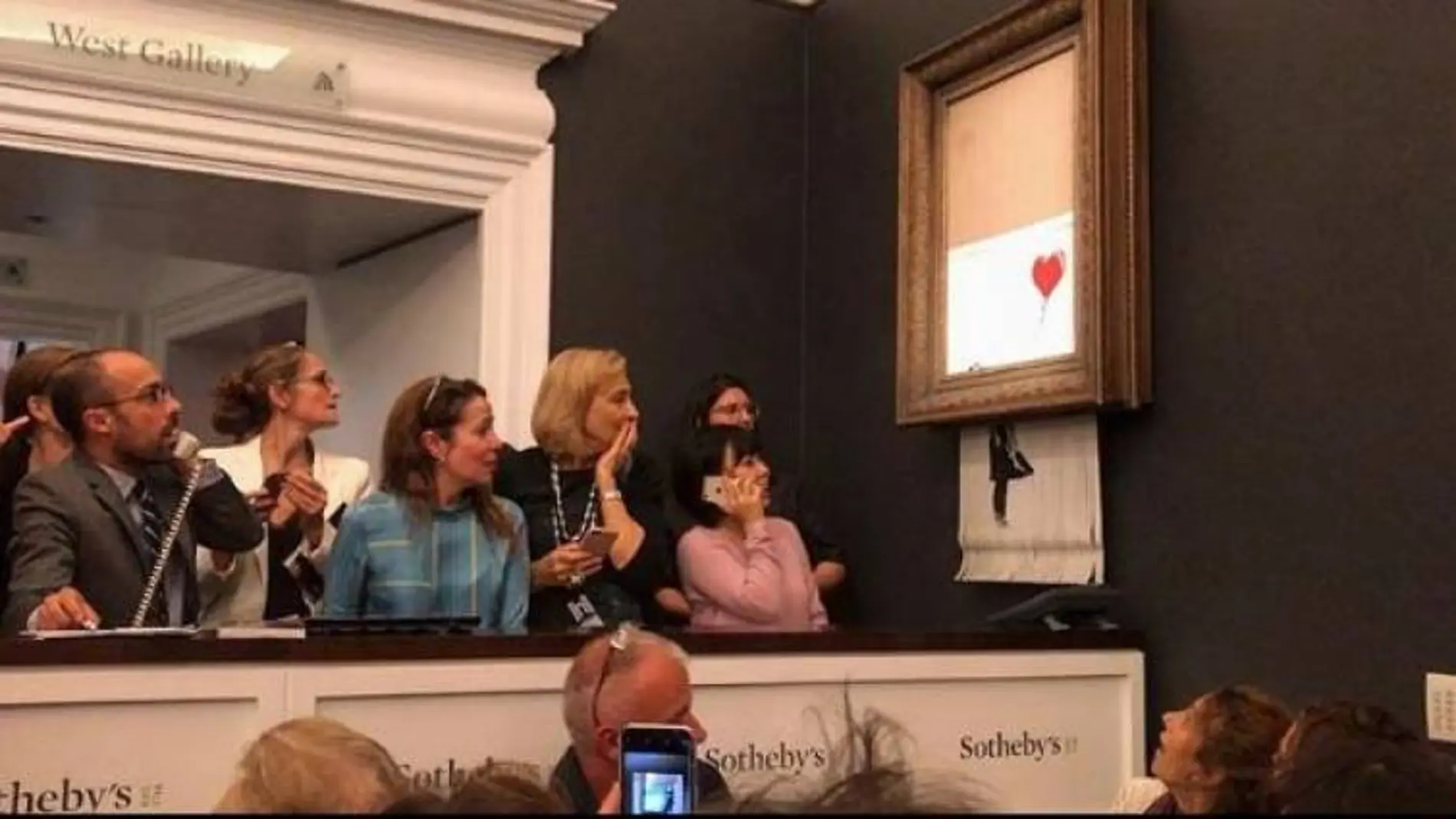 Momento en el que la obra pasa por la trituradora de papel / Instagram Bansky