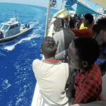 os inmigrantes que viajan a bordo del barco «Lifeline» observan la llegada de un buque maltés que les trae víveres tras cinco días a la deriva