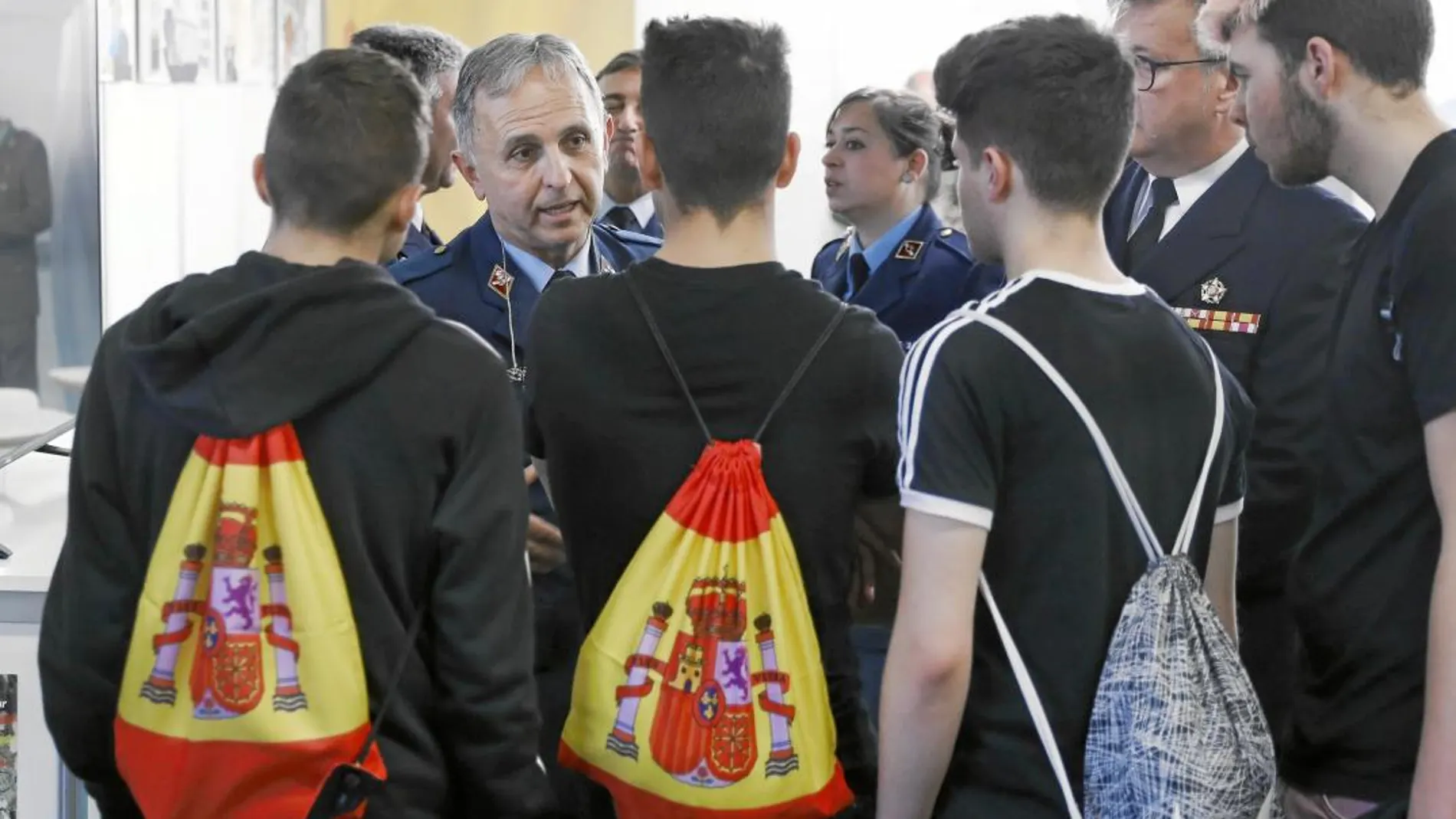 El subteniente Molina informa a unos jóvenes que responden con gritos de «Viva España» a los activistas contrarios al estand