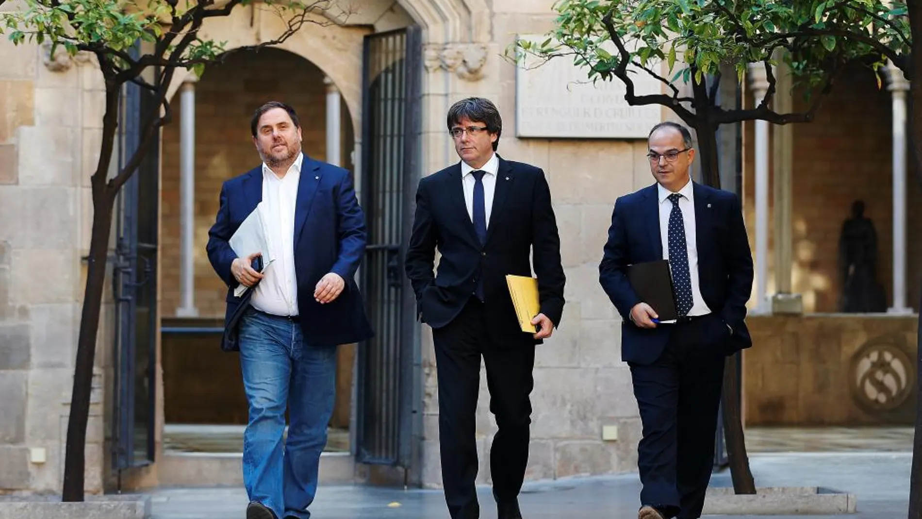 El presidente de la Generalitat, Carles Puigdemont (c), su vicepresidente, Oriol Junqueras (i), y el conseller de Presidencia, Jordi Turull (d), a su llegada a la reunión semanal del gobierno catalán