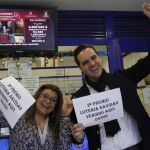 Marcos Delgado, dueño de la administración de lotería ubicada en la calle Condesa de Venadito en Madrid, acompañado de la vendedora Jenyffer Hoyos celebran su segundo premio