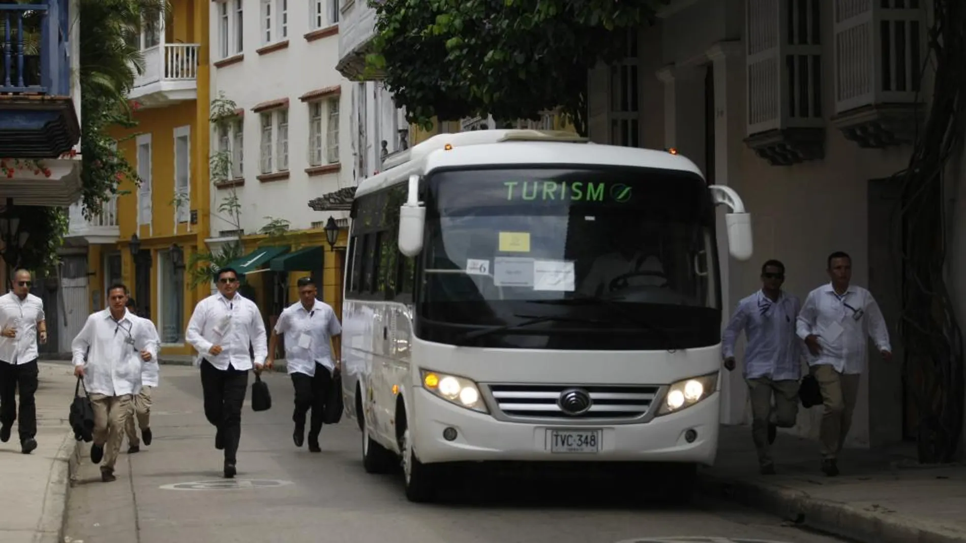 Miembros de seguridad escoltan junto a un autobús con algunos de los mandatarios que asisten a la firma del acuerdo de paz