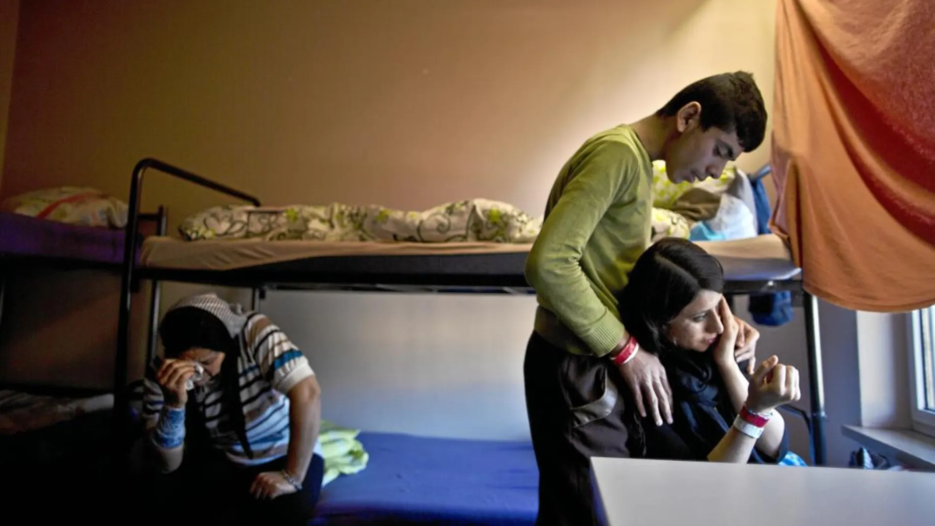 Un refugiado yazidí consuela a su hermana en un centro de refugiados en Heidelberg (Alemania)