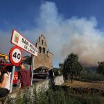 Vecinos de San Miguel de Langre observan el denso humo y las llamas acercándose sus casas