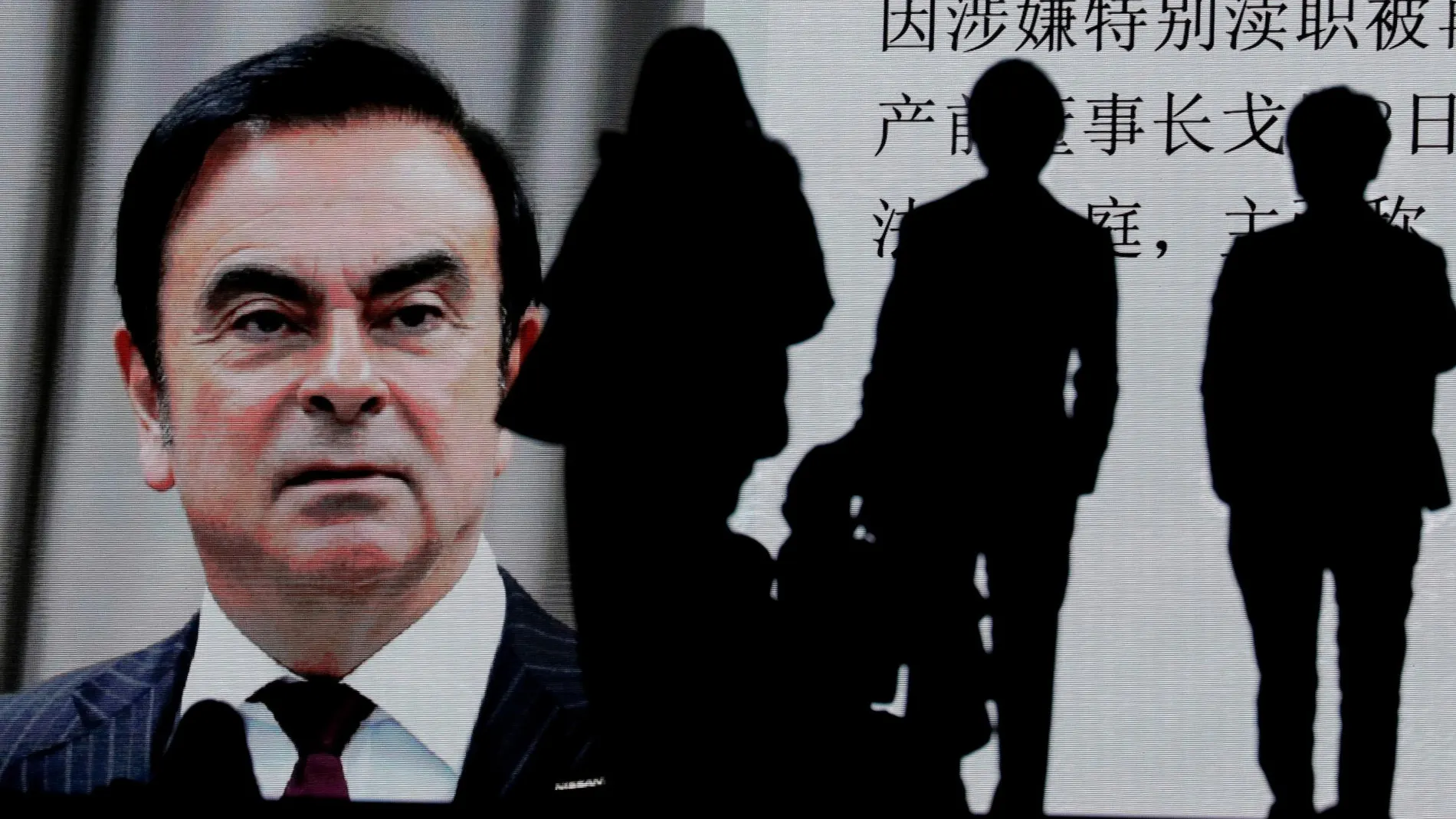 Peatones observan una pantalla que muestra una pieza informativa sobre el expresidente de Nissan Carlos Ghosn con motivo de su primera comparecencia ante el juez en Tokio (Japón) / Foto: Efe