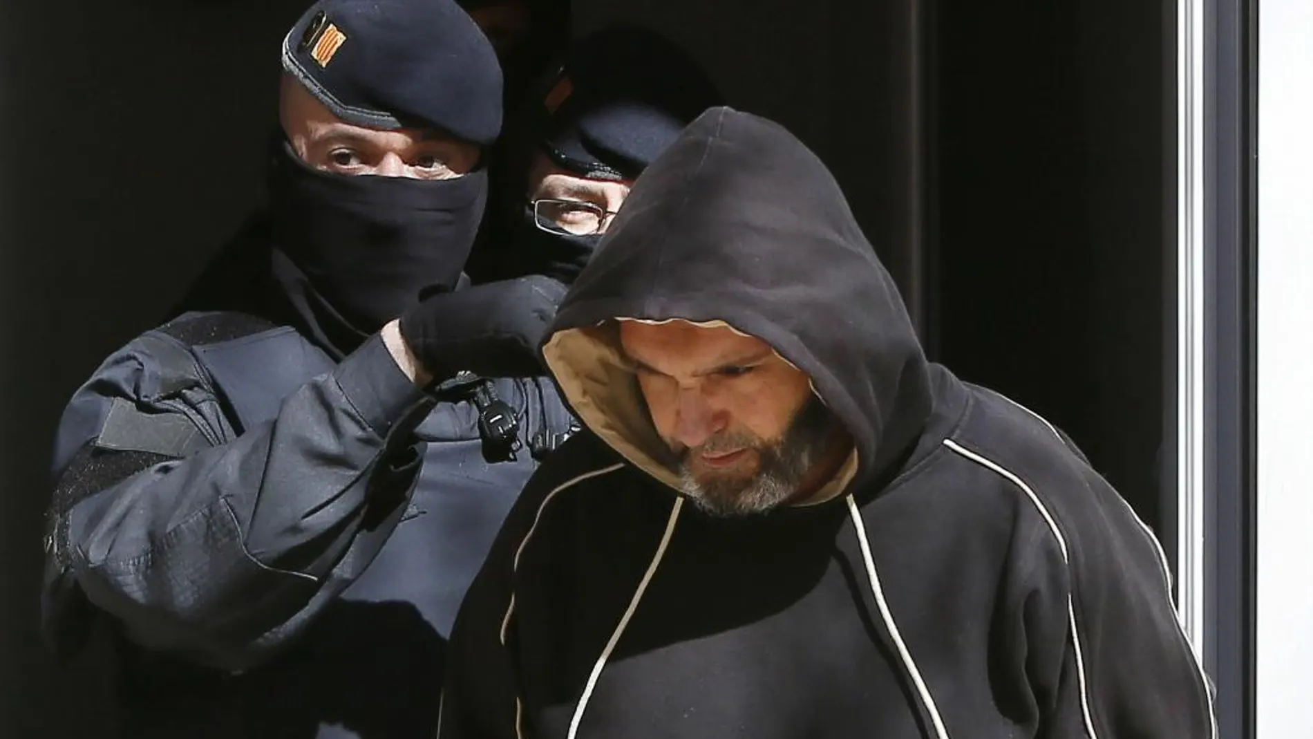 Agentes de los Mossos d'Esquadra junto a uno de los detenidos en el marco de una operación contra el terrorismo yihadista