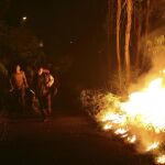 Varios vecinos intentan sofocar las llamas del incendio forestal de Arbo (Pontevedra).