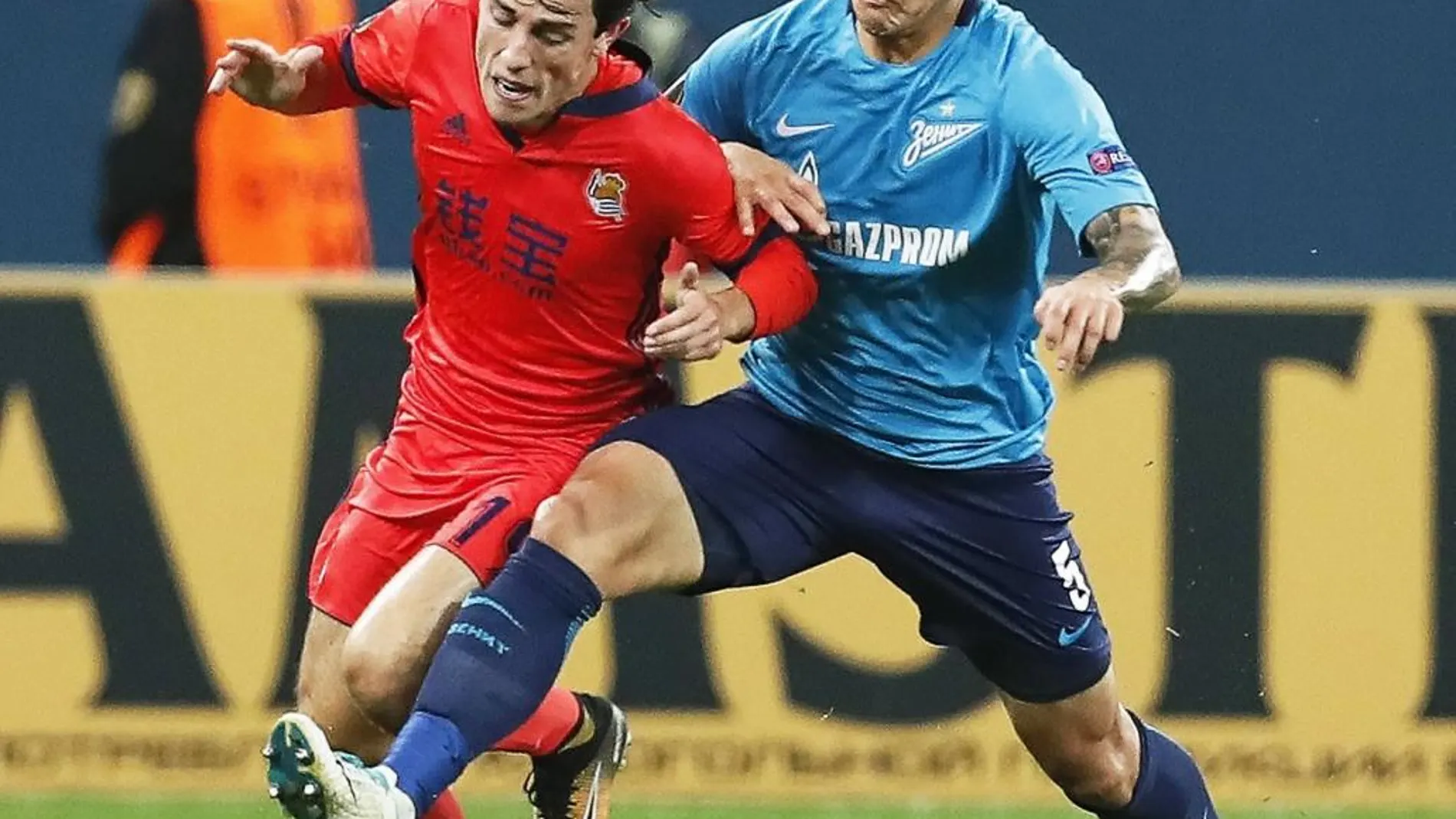 El jugador de la Real Sociedad, Álvaro Odriozola, pelea por el control del balón con el jugador del Zenit, Leandro Paredes