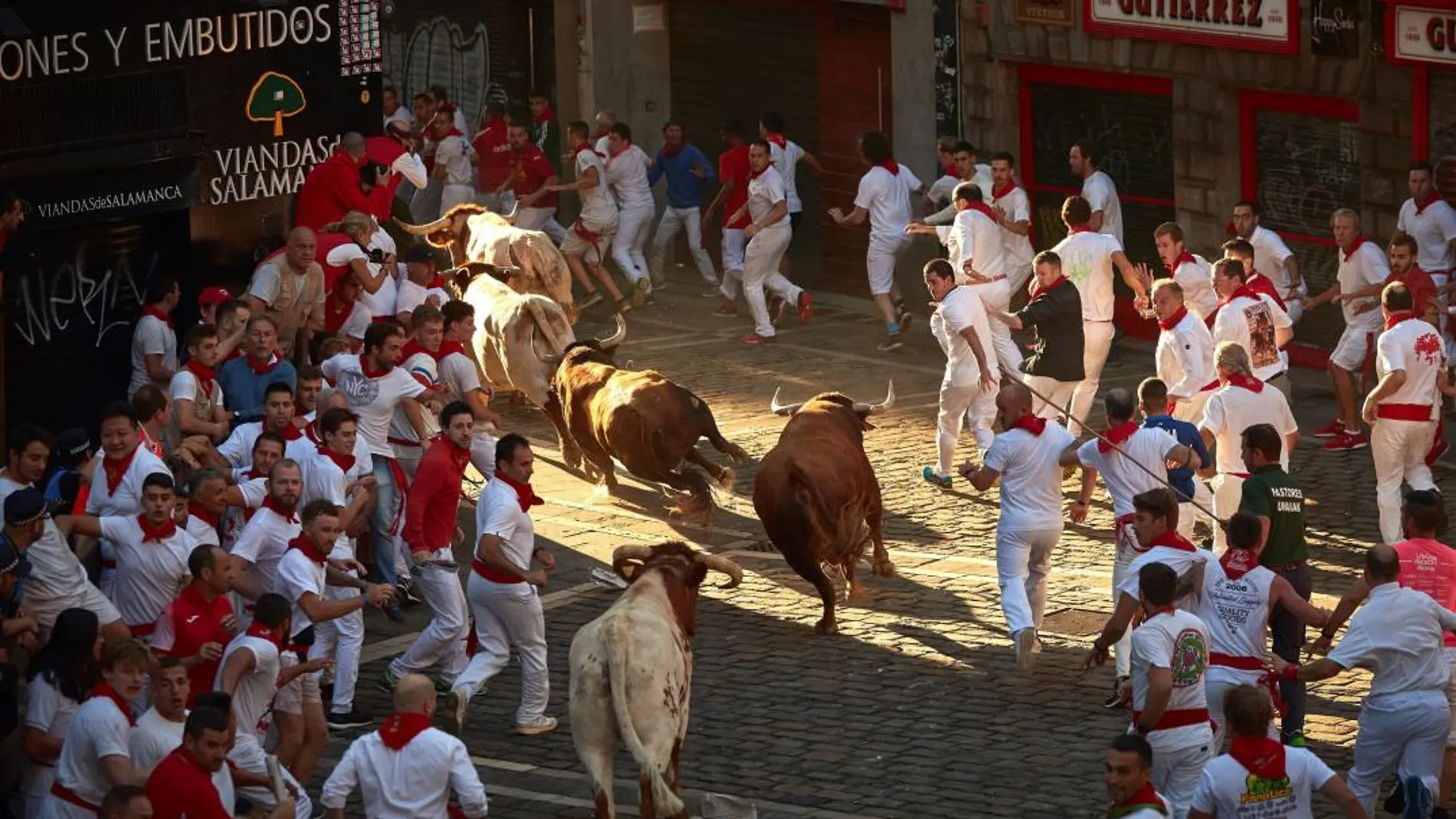 Los toros de la ganadería gaditana de Cebada Gago al final de la cuesta de Santo Domingo durante el tercer encierro de los Sanfermines 2018.