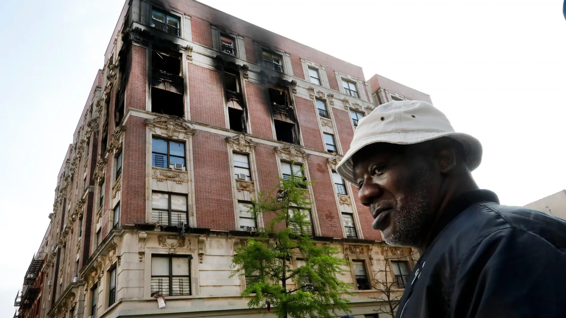 Un residente del apartamento quemado en el incendio registrado en el barrio neoyorquino de Harlem / Ap