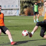 Bale, durante el último entrenamiento, disputa el balón con el canterano Manu Hernando, listo para jugar contra el Fuenlabrada