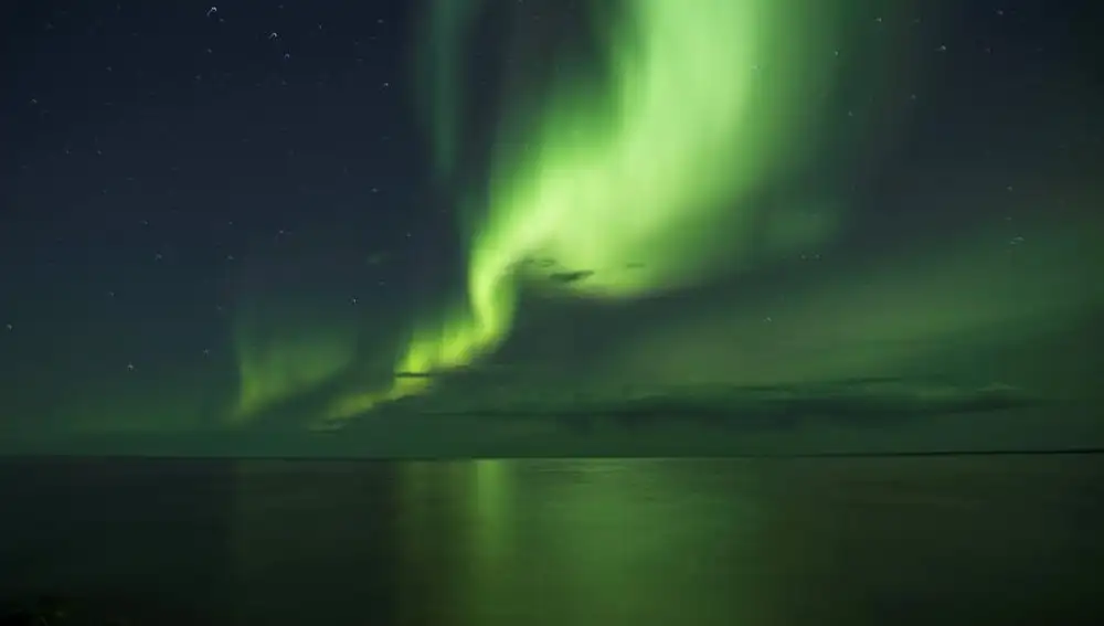 En la imagen, una aurora boreal sobre un lago de Canadá