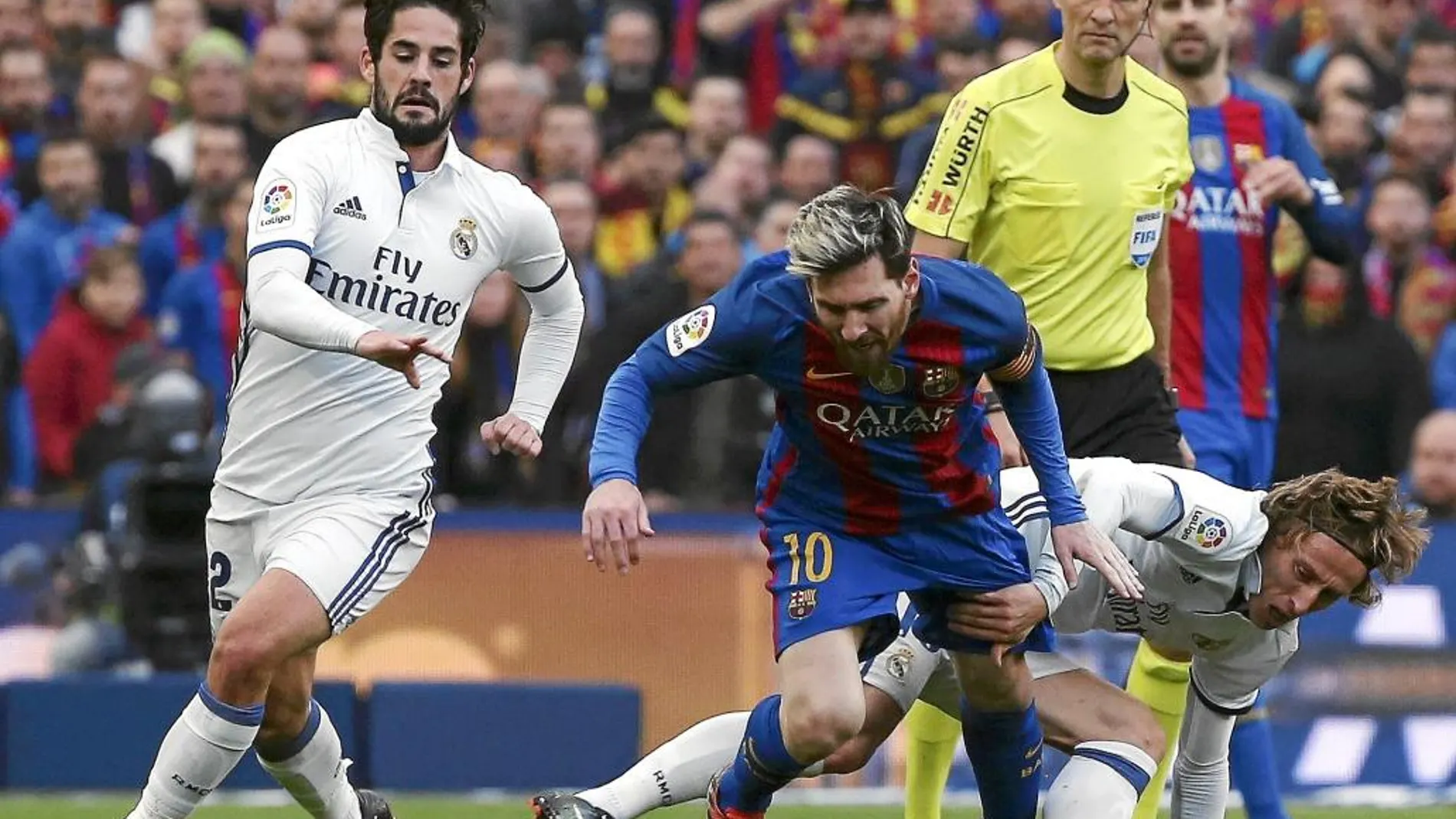 Messi y Modric pelean por un balón ante la mirada de Clos Gómez